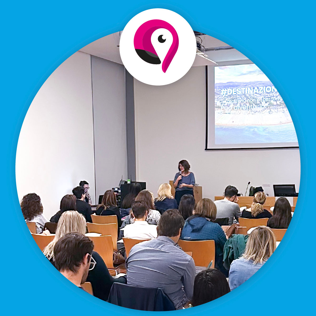Una relatrice parla davanti a una platea in aula universitaria, mentre sullo schermo è proiettata una slide con il titolo “#Destinazione”. Il pubblico ascolta e prende appunti. Colori caldi e logo su sfondo azzurro.