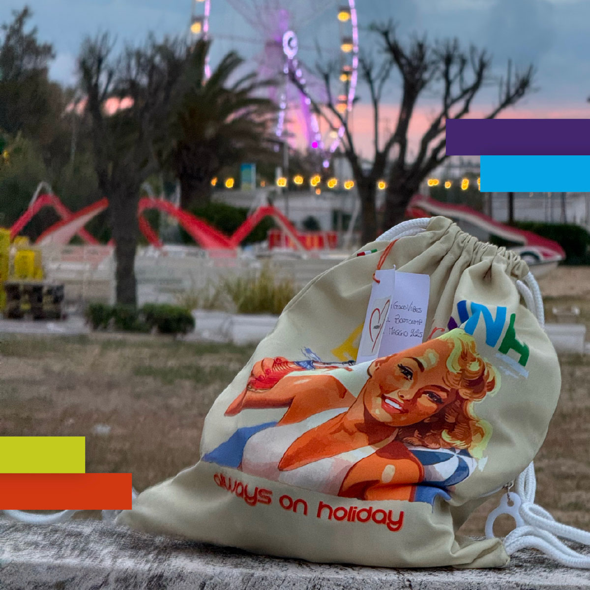 Sacca promozionale in tessuto con illustrazione vintage di donna in costume e la scritta “Always on holiday”. Sullo sfondo la ruota panoramica di Rimini accesa al tramonto.
