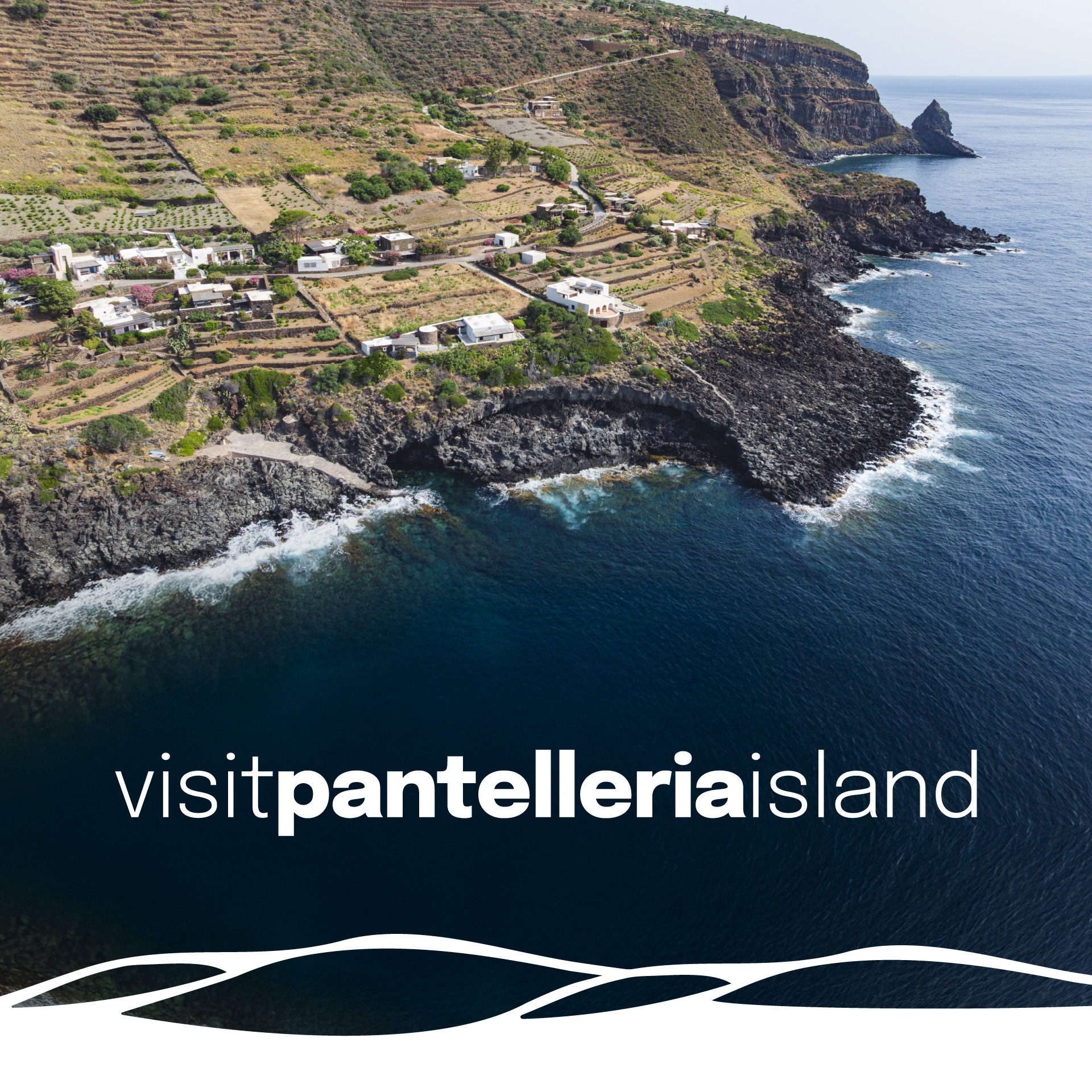 “Veduta aerea della costa di Pantelleria con le tipiche terrazze coltivate e le case dammuso affacciate sul mare. In basso il logo ‘visitpantelleriaisland’. L’immagine rappresenta l’identità visiva della destinazione.”