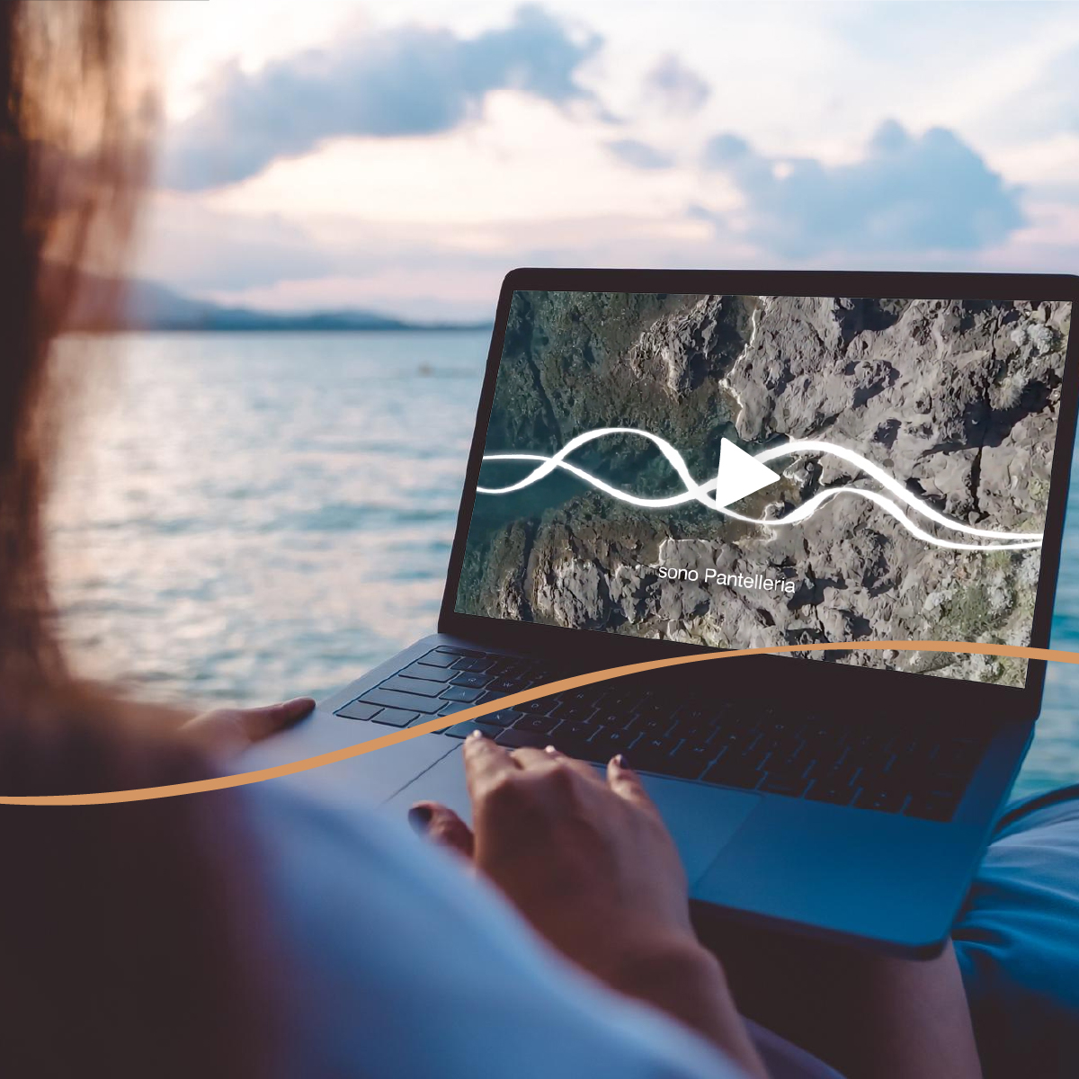 “Persona che guarda un video sul laptop con il titolo ‘Sono Pantelleria’, seduta vicino al mare al tramonto. L’immagine evoca l’esperienza digitale e immersiva del brand Visit Pantelleria Island.”