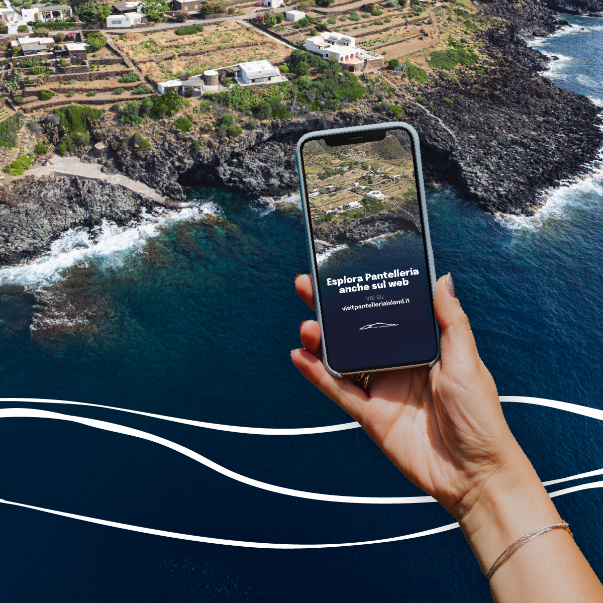 “Mano che regge uno smartphone con la scritta ‘Esplora Pantelleria anche sul web’ davanti alla costa rocciosa dell’isola con mare blu e case bianche. Grafica con onde bianche stilizzate in primo piano.”