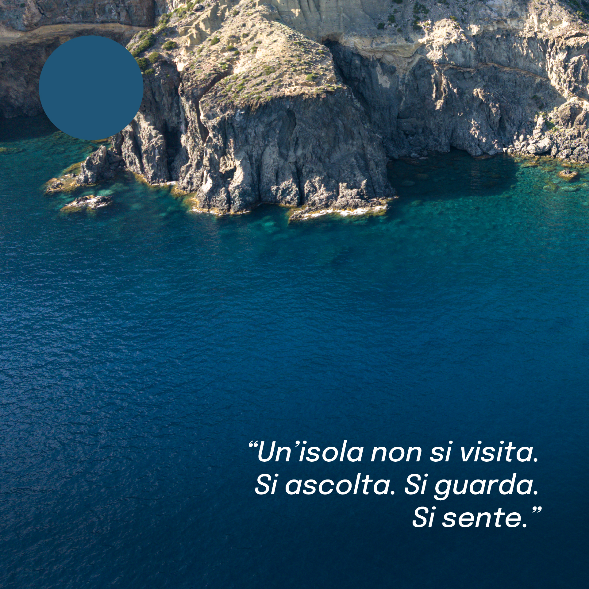 “Scogliera di Pantelleria immersa nel mare turchese, vista dall’alto. In alto a sinistra un campione di colore blu mare e, in basso, la frase: ‘Un’isola non si visita. Si ascolta. Si guarda. Si sente.’”
