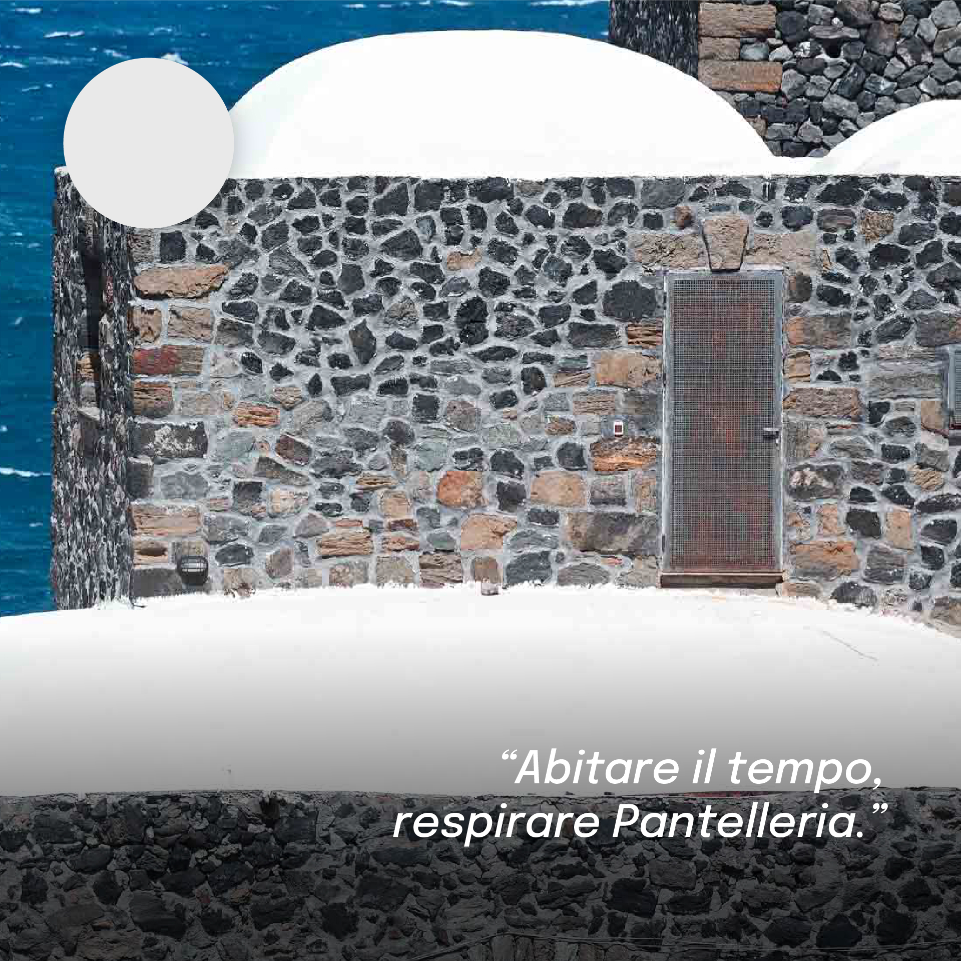 “Particolare di un dammuso di Pantelleria, con pareti in pietra lavica e tetto bianco a cupola, affacciato sul mare. In alto un campione di colore grigio chiaro e la frase: ‘Abitare il tempo, respirare Pantelleria.’”