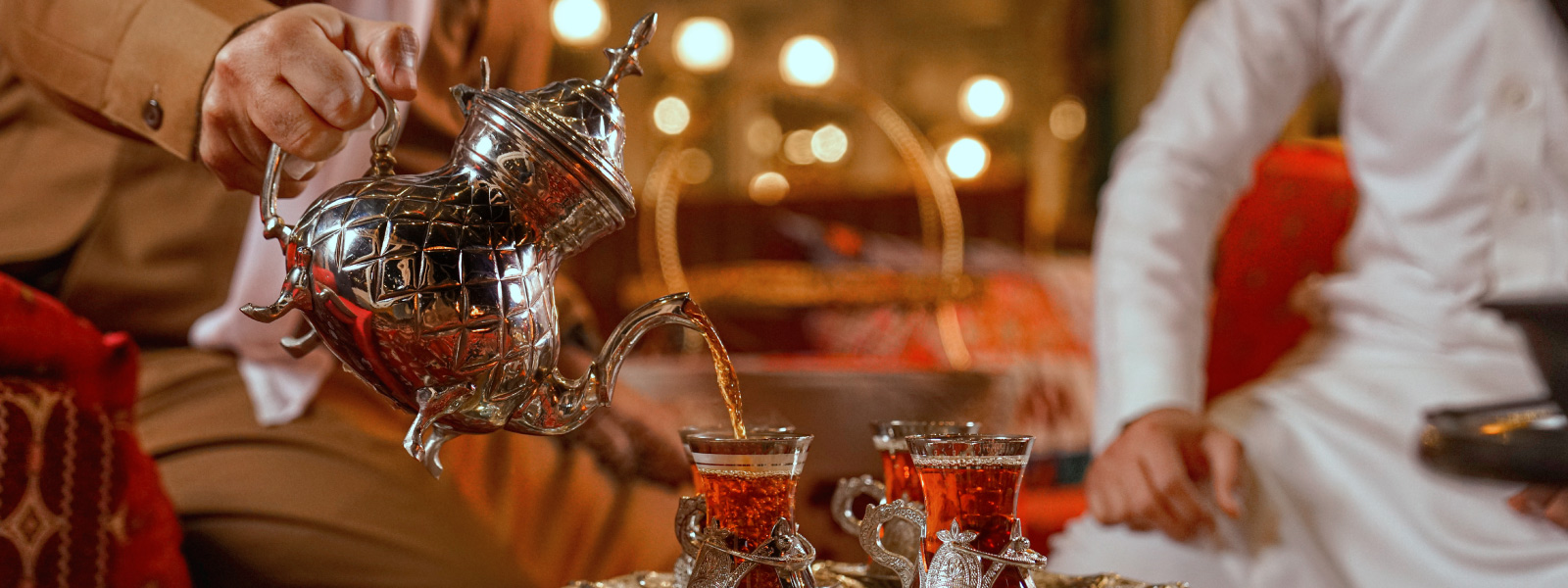 Tè servito in bicchieri tradizionali durante un’esperienza gastronomica locale, rappresentazione del travel trend 2026 dedicato al turismo culinario.